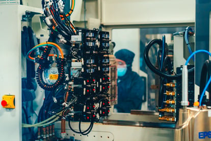 Saint-Gobain-Spritzgussmaschine mit Mitarbeiter im Hintergrund