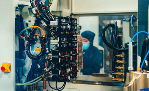 Saint-Gobain-Spritzgussmaschine mit Mitarbeiter im Hintergrund