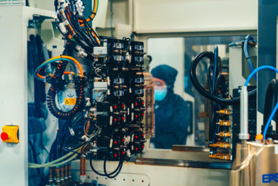 Saint-Gobain-Spritzgussmaschine mit Mitarbeiter im Hintergrund